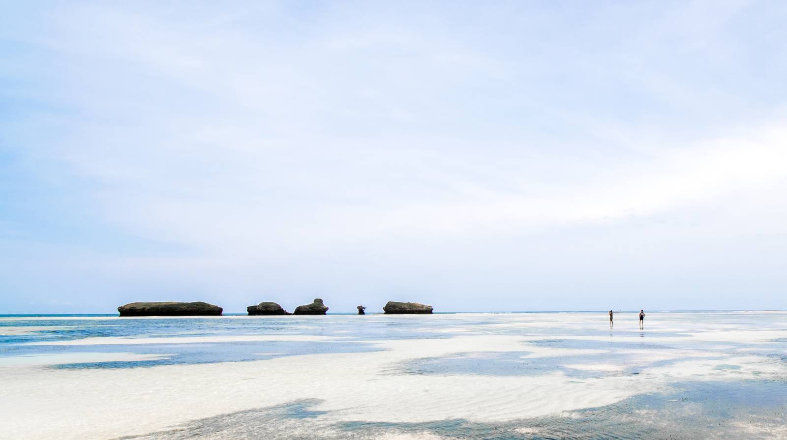Two guests walking at low tide on a solitary beach